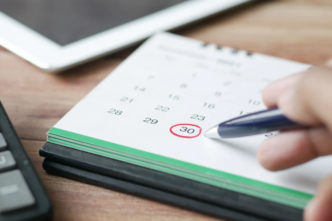 Woman using a laptop to manage her weekly schedule with a digital calendar, representing automated online booking systems for service businesses
